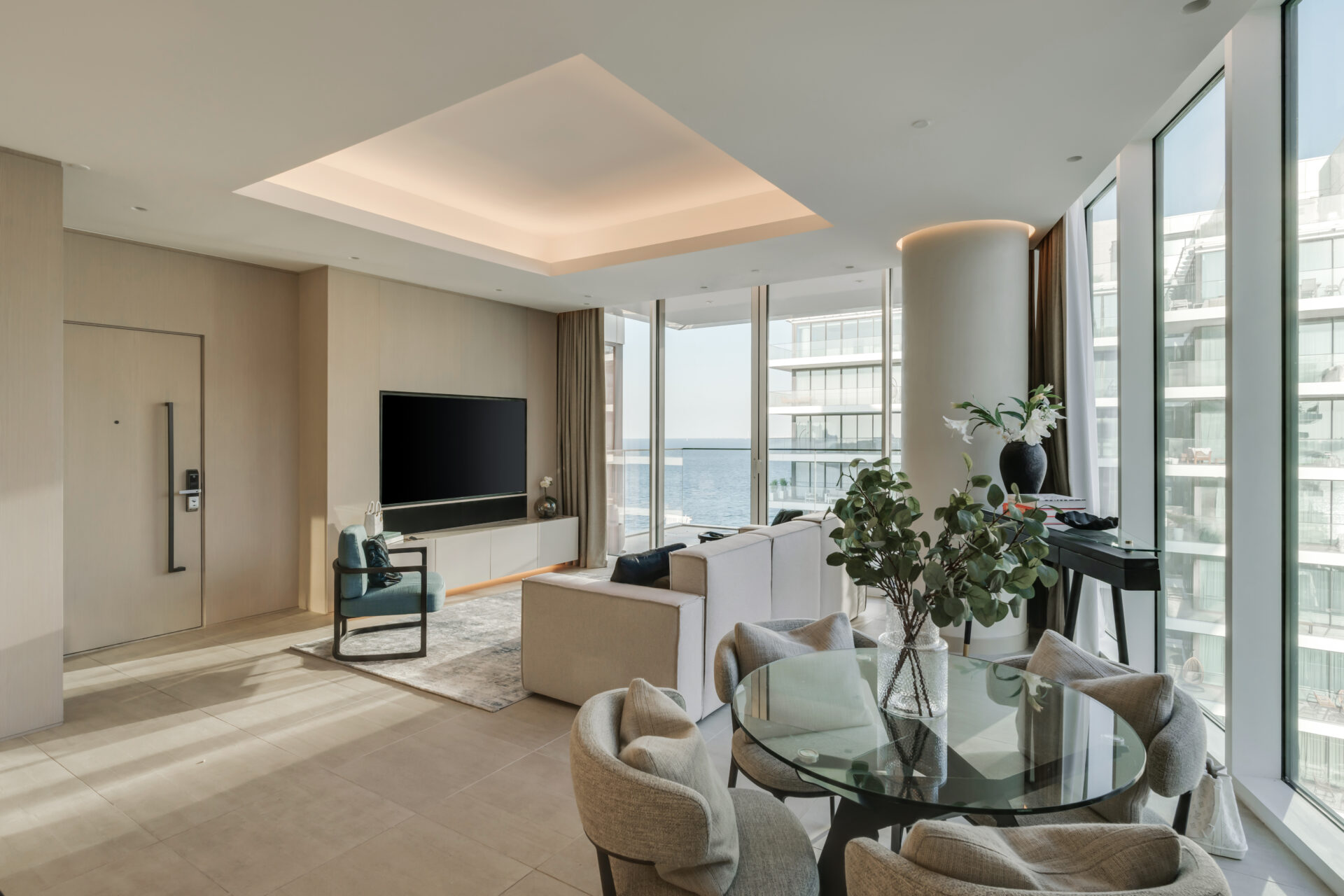 Modern open-plan living and dining area in Serenia Residences, Palm Jumeirah, featuring sea views, floor-to-ceiling windows, custom furniture, and contemporary neutral-toned interiors.