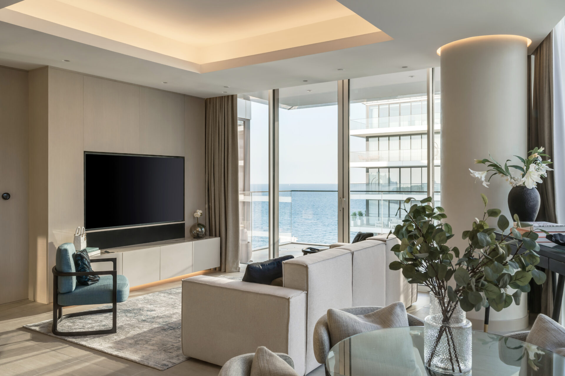 Luxury living room in Serenia Residences, Palm Jumeirah, with sea views, custom media wall, and modern neutral furnishings.