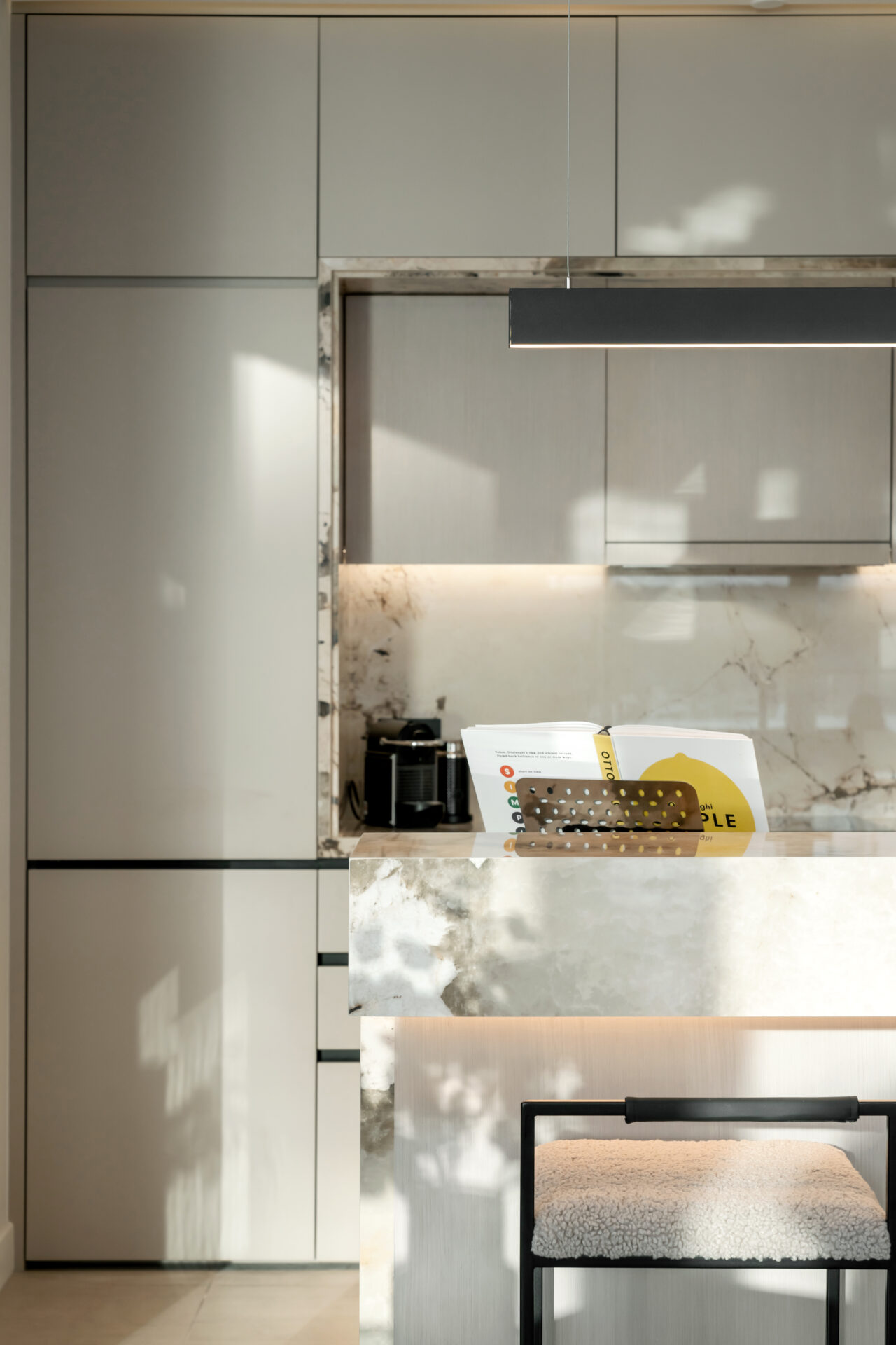 Close-up of marble breakfast bar with integrated lighting and modern cabinetry in Serenia Residences, Palm Jumeirah.