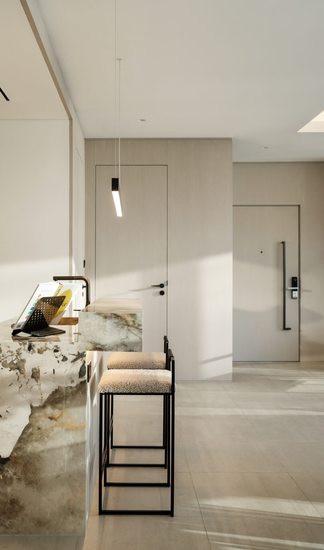 Marble breakfast bar with upholstered bar stools and view towards entryway in Serenia Residences, Palm Jumeirah.
