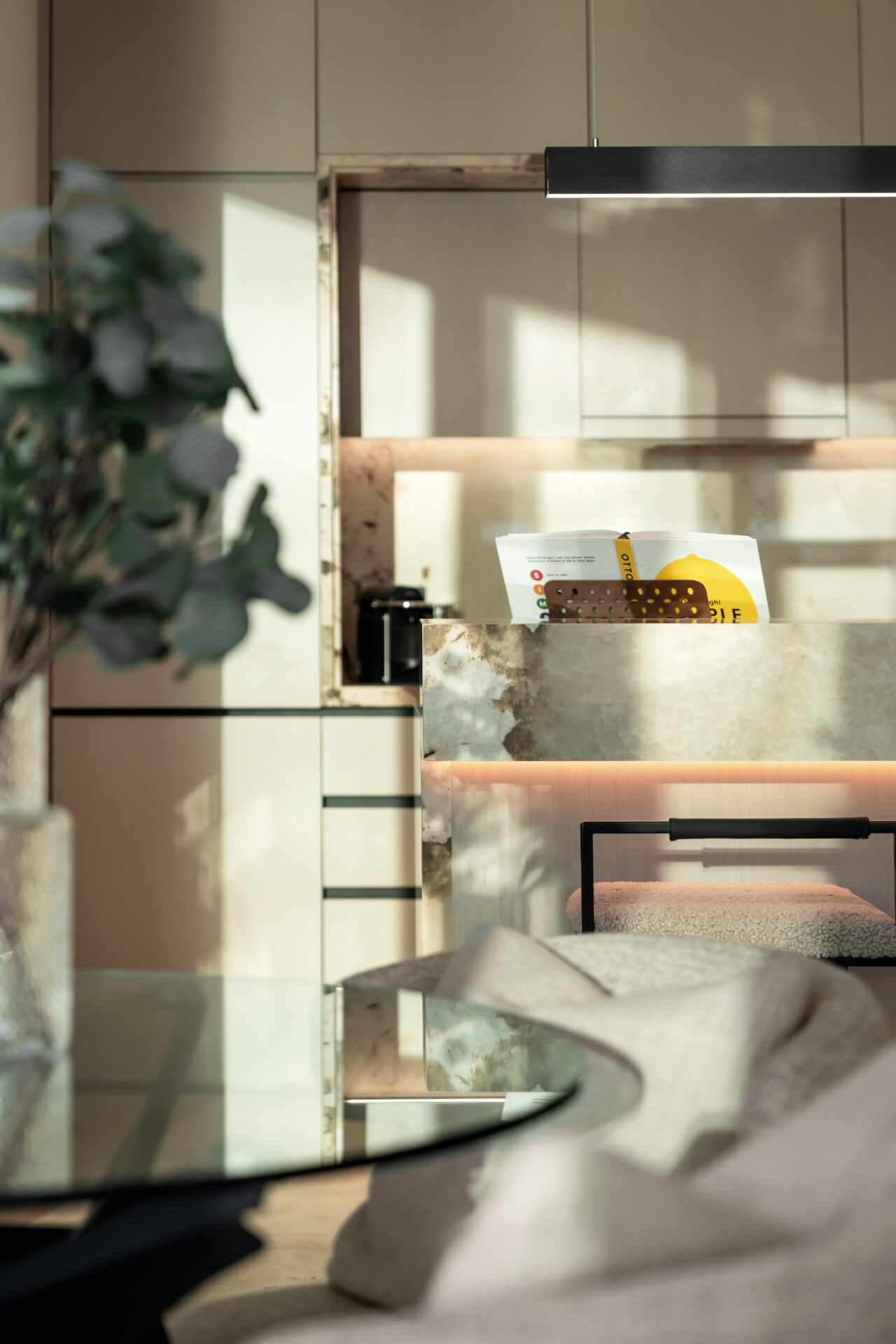 Side angle of kitchen island highlighting marble textures and lighting.