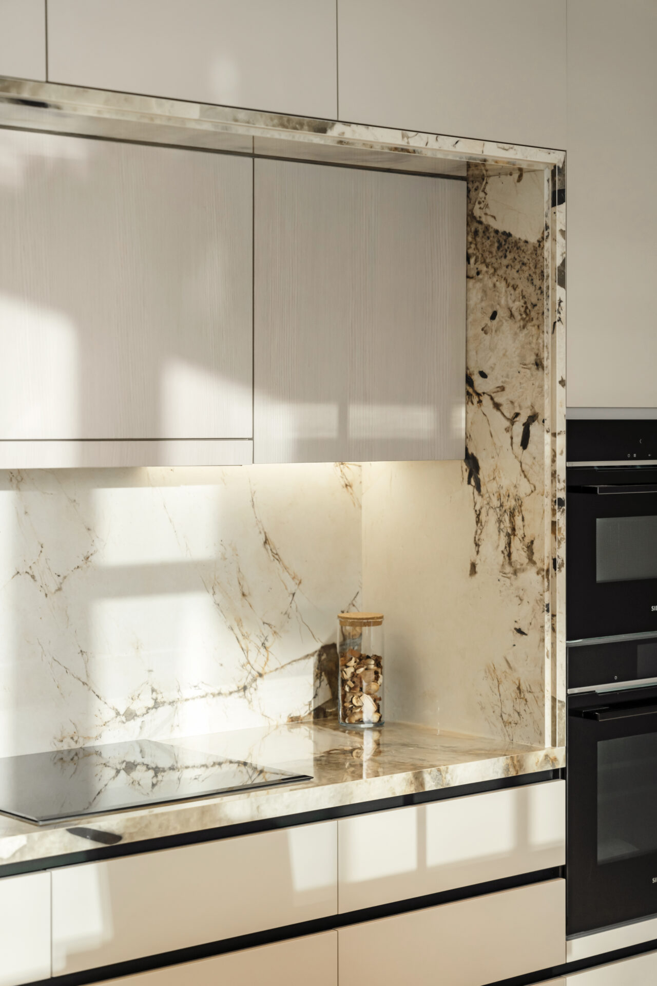 Close-up of marble veining on kitchen backsplash in natural light.
